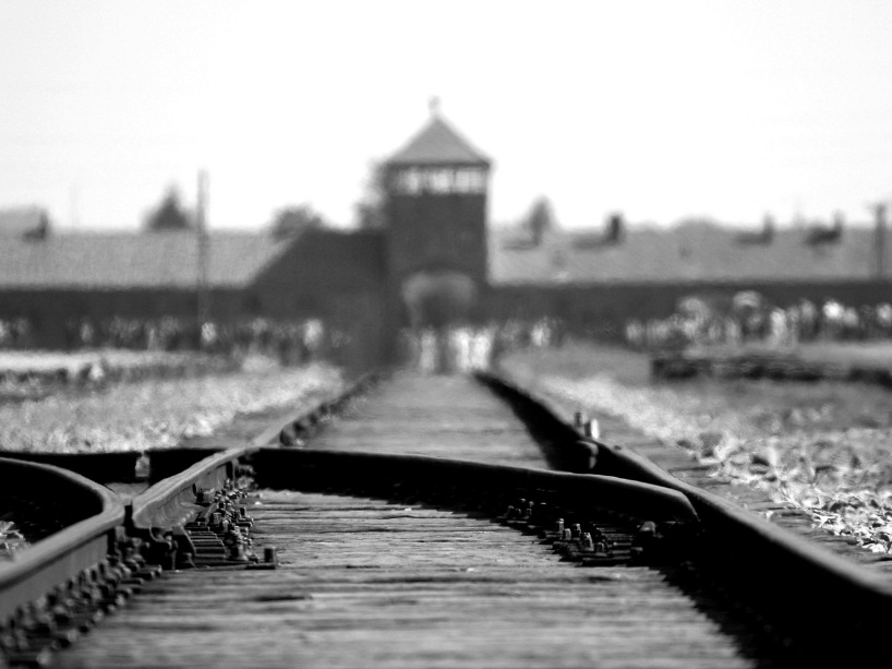 A black and white photo of the entrance of a concentration camp.