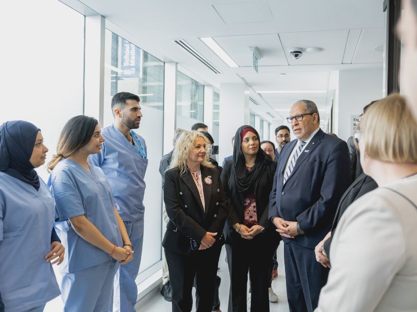 TMu President Mohamed Lachemi chats with government officials, TMU student residents and TMU administrators inside the new clinic.