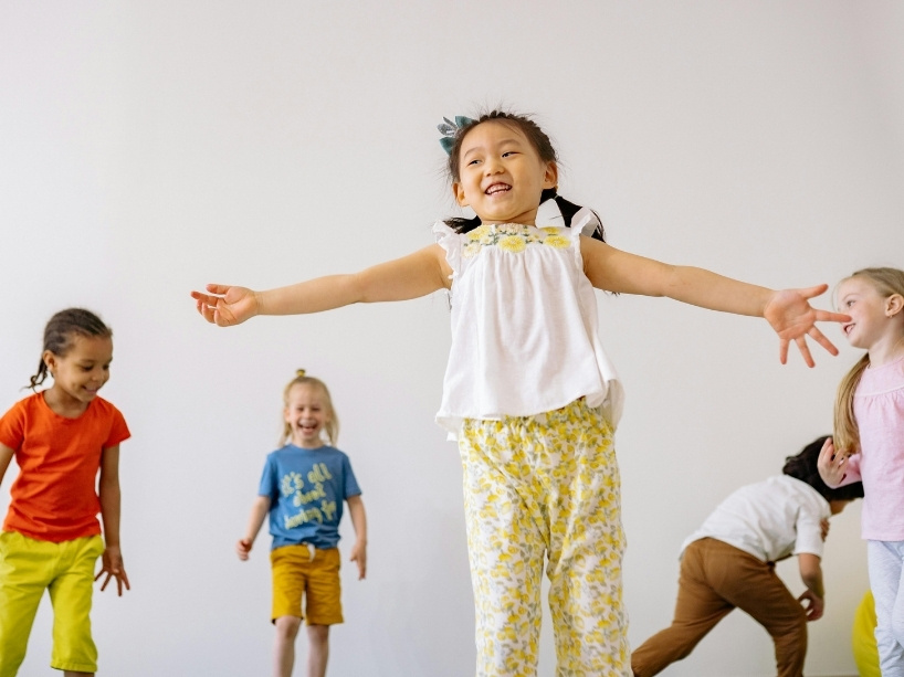 Kids standing and playing against a white backdrop.