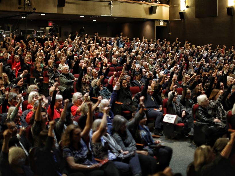 The people in attendance at Stephen Lewis’ memorial raising their fists in solidarity.