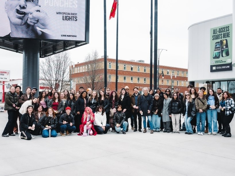 A group of students and guests pose for a photo together at the TD Coliseum in Hamilton, Ontario as part of the audience for the JUNO Awards dress rehearsal. 
