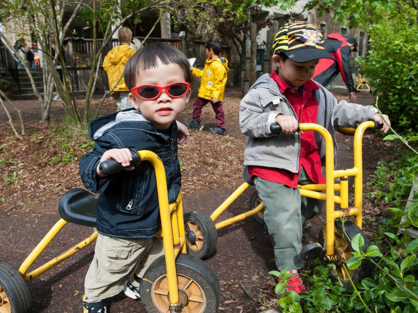 Toddlers on tricycles at TMU campus daycare