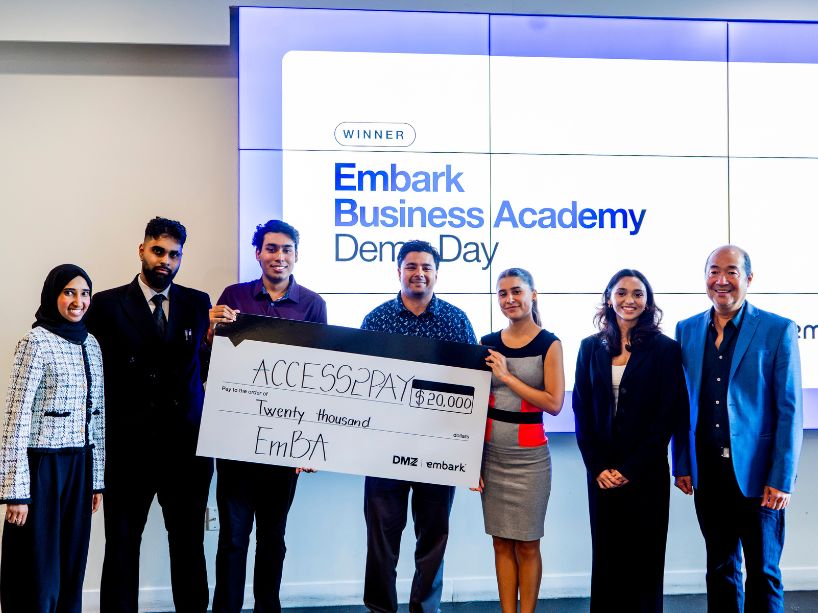 Team Access2Pay and DMZ staff celebrate on stage after winning the $20,000 top prize at the Embark Business Academy Demo Day
