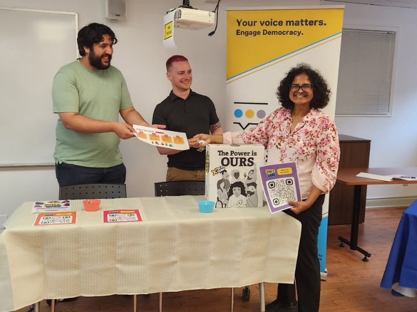Three people at a Voice the Vote table with flyers.