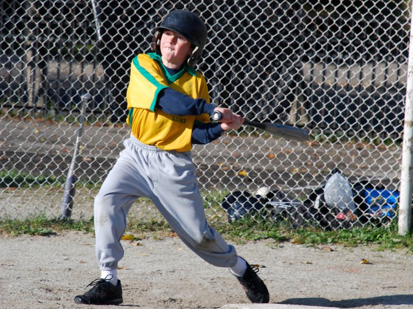 Young Liam Hicks swinging a baseball bat.