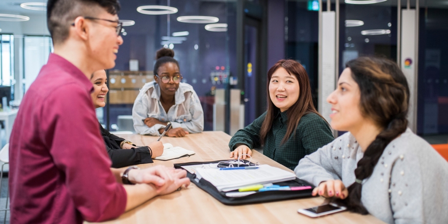 Group of students in conversation around a table