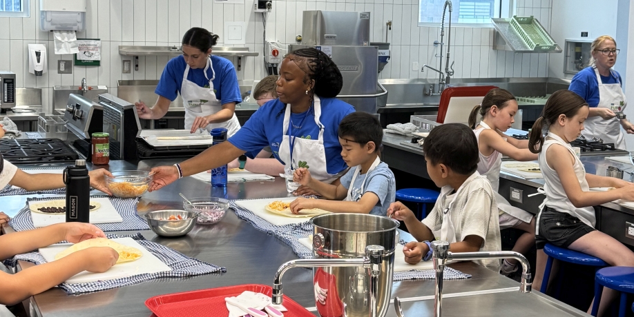 Children and instructors working in a kitchen