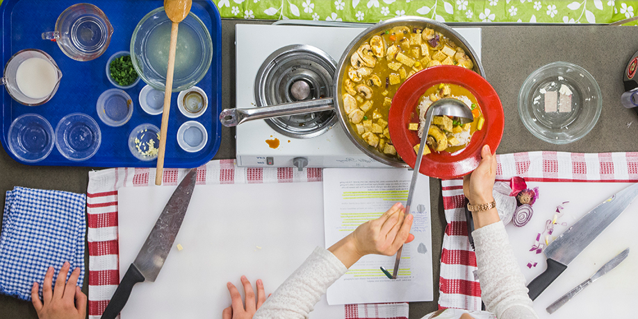 Aerial view of of hands preparing stew 