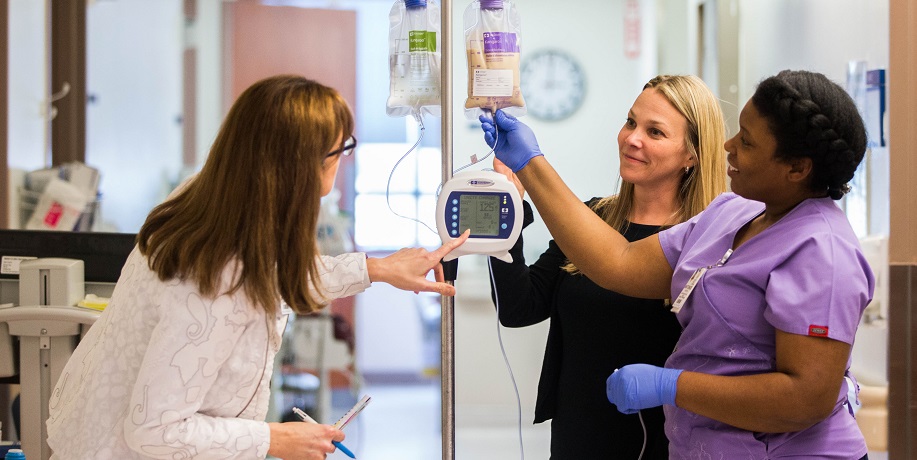 nursing student setting up IV with the help of instructor 