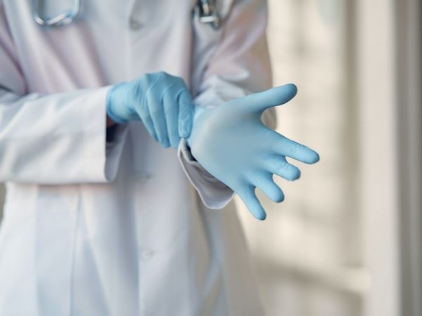 Person putting on medical gloves Person putting on medical gloves