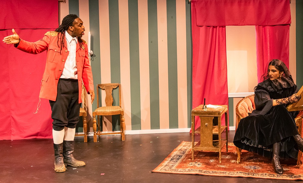 students stand onstage in period costumes engage in discussion