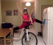 In their kitchen, a clown balances precariously on a bicycle looking triumphant.
