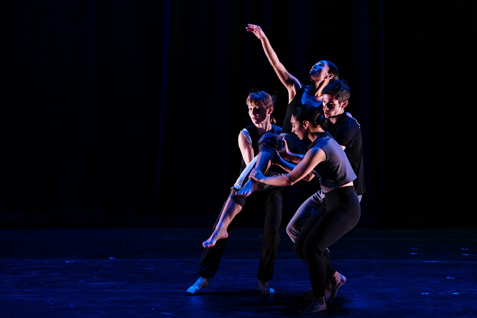 A dancer is carried by two others
