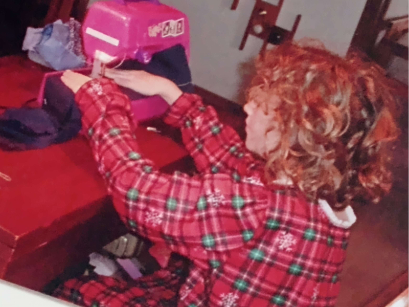 A young Alexander sews with a hot pink sewing machine