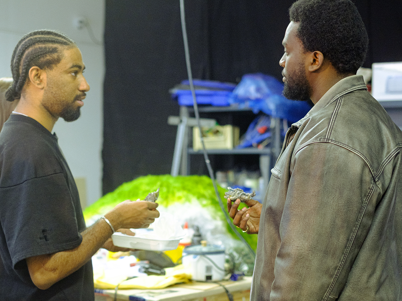 Michael Wamara and Akash Jones stand together on the set of the Give Me Love Give Me Peace On Earth Music Video