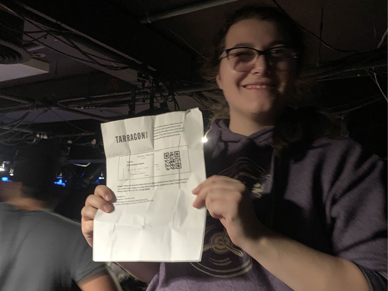 A student stands proudly holding her ticket to a Tarragon Theatre production 