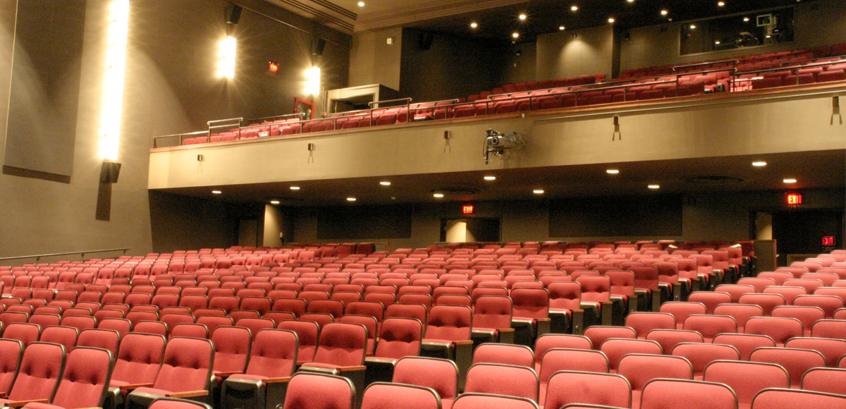 Red chairs in the orchestra of the Theatre at The Creative School audience.