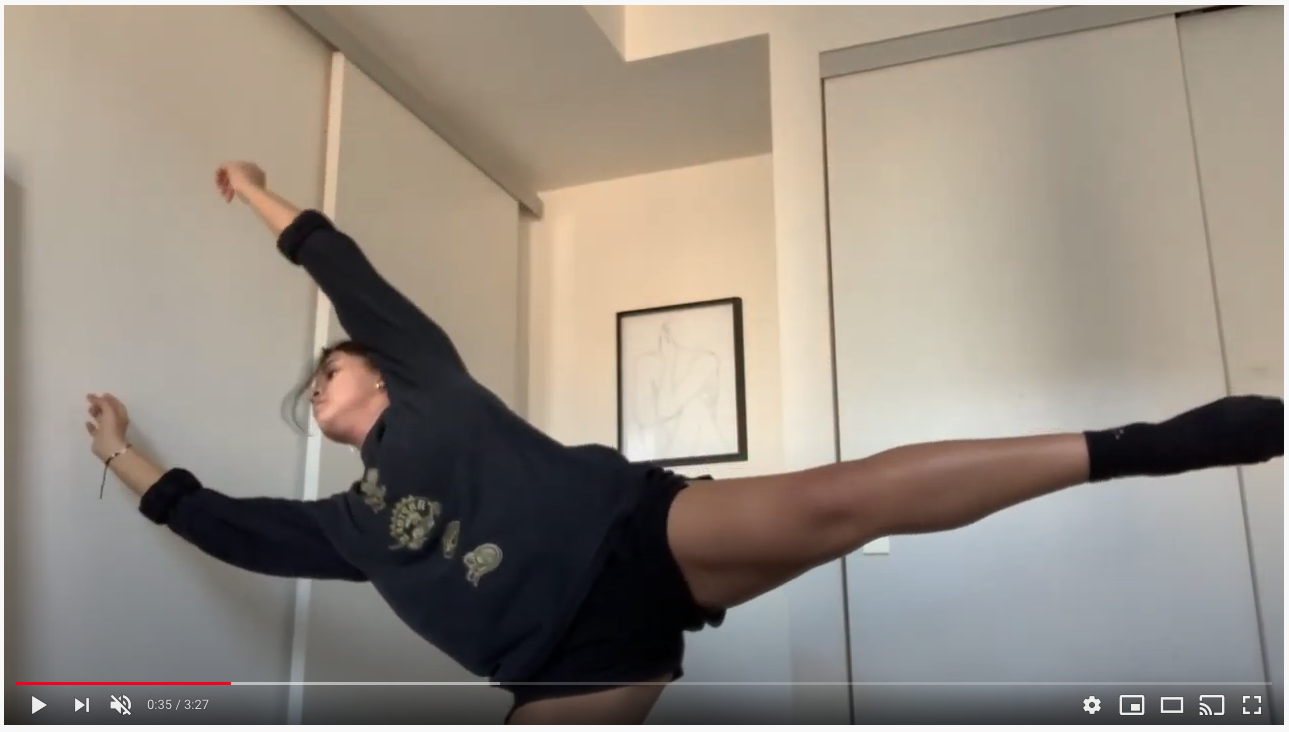 A dancer in a small home space stand on one leg and reaches in opposite directions