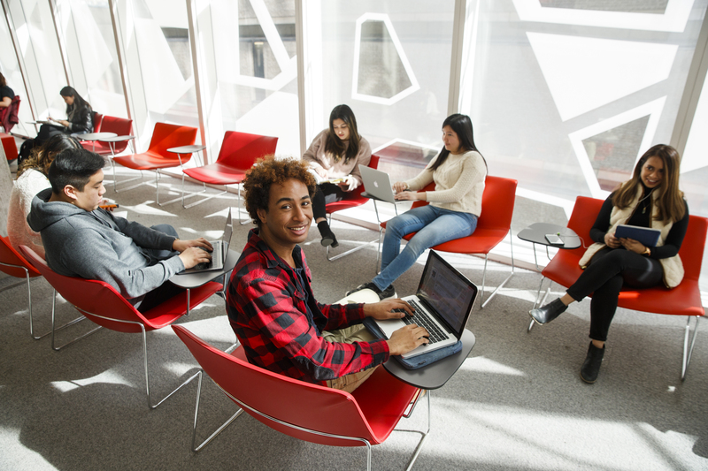 Students study group in the Student Learning Centre sitting on red chairs.