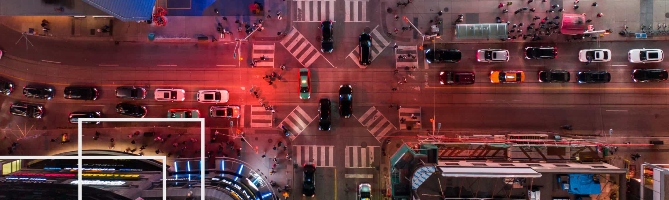 A busy intersection with cars and people in downtown Toronto