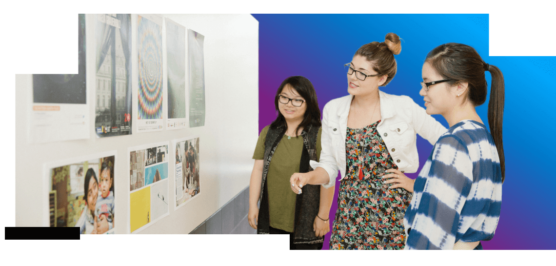 3 ProCom students reviewing posters on taped to a white board