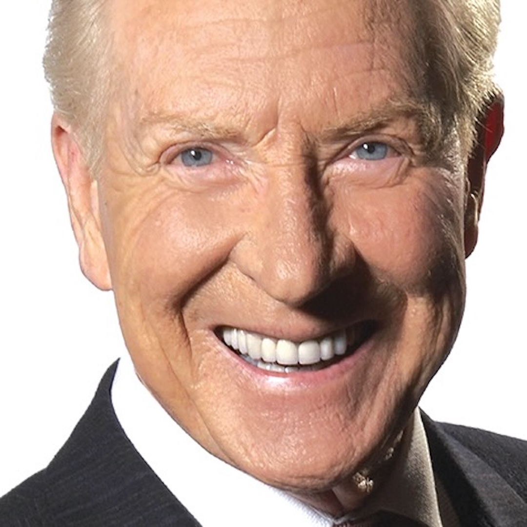 A close-up headshot of Dave Devall. He has short white hair, blue eyes, and is smiling. He is wearing a light blue collared shirt and is posed against a grey backdrop.