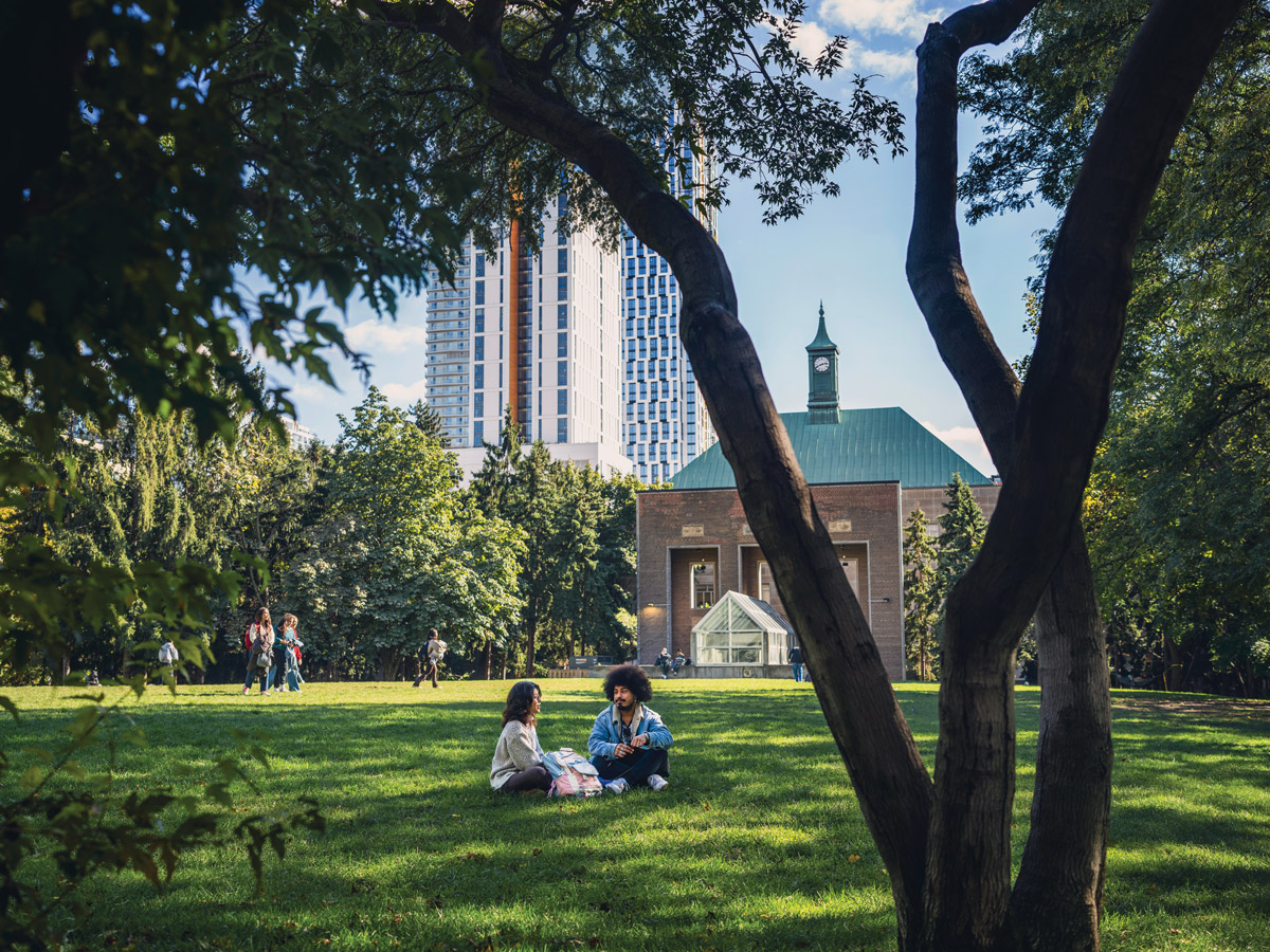 Students sitting on the green grass of the Kerr Hall Quad on a sunny day.