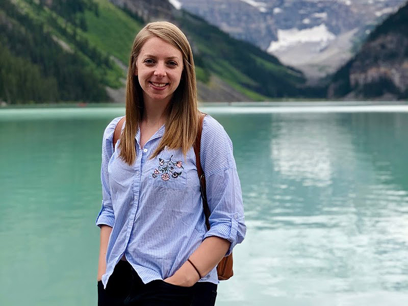 Jeanette Korosi standing in front of a lake looking at the camera.