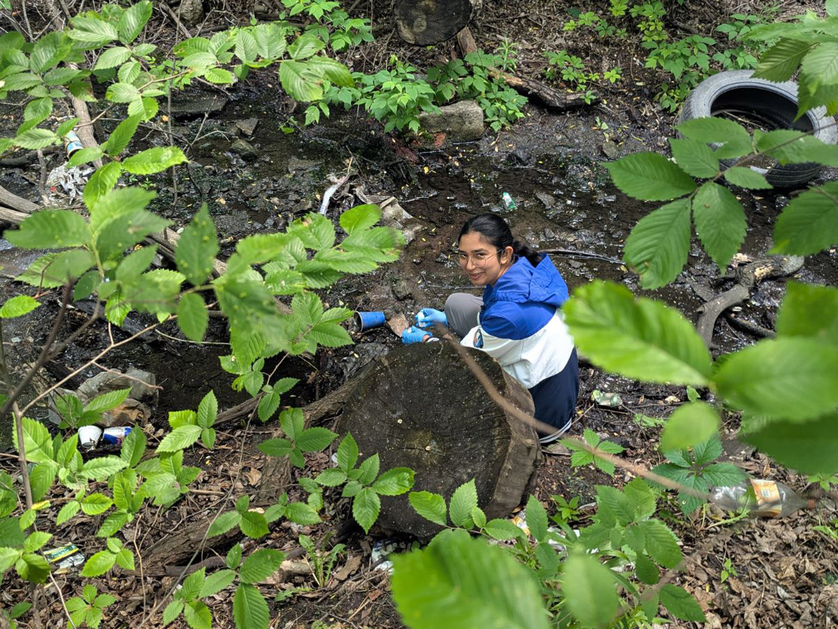 Environmental and Urban Sustainability student, Gagan, traces local urban watershed from its headwater during a program field trip.