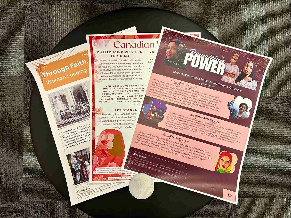 Three student created posters resting on a table.