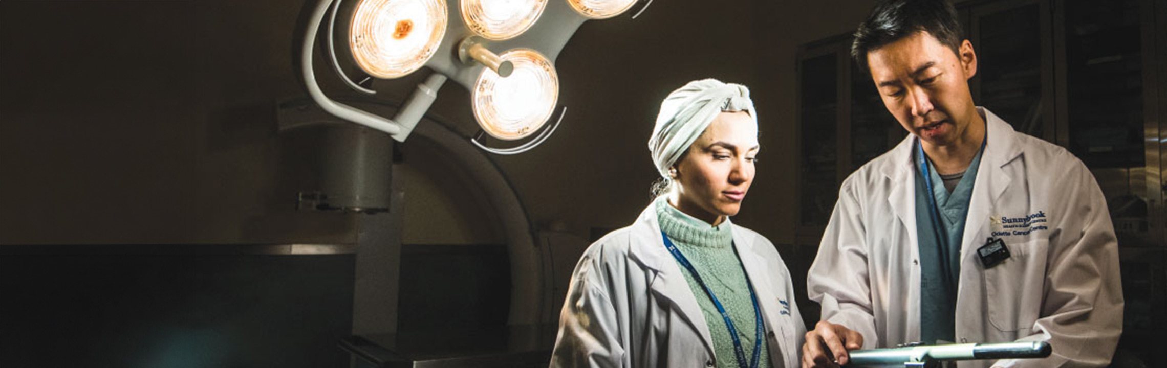 A pair of doctors look over their equipment in a hospital imaging lab.