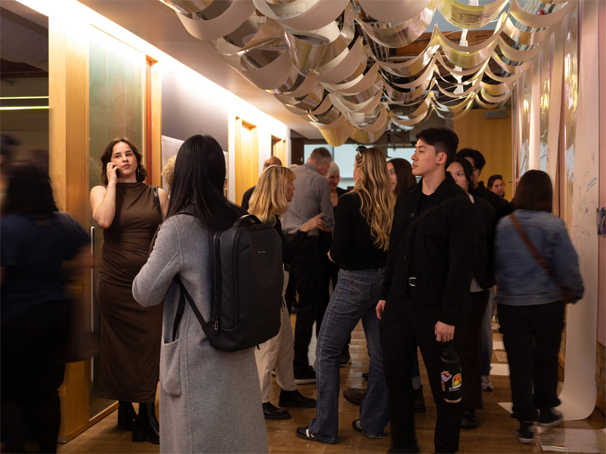 Guests at the YES 2025: Reflections student showcase observe the space around them.