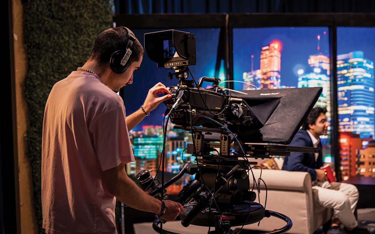 A student looks at the scene ahead through a screen on a film camera.