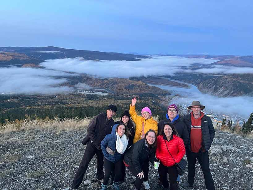 Hospitality and Tourism students gather for a group photo on top of a mountain in Yukon.