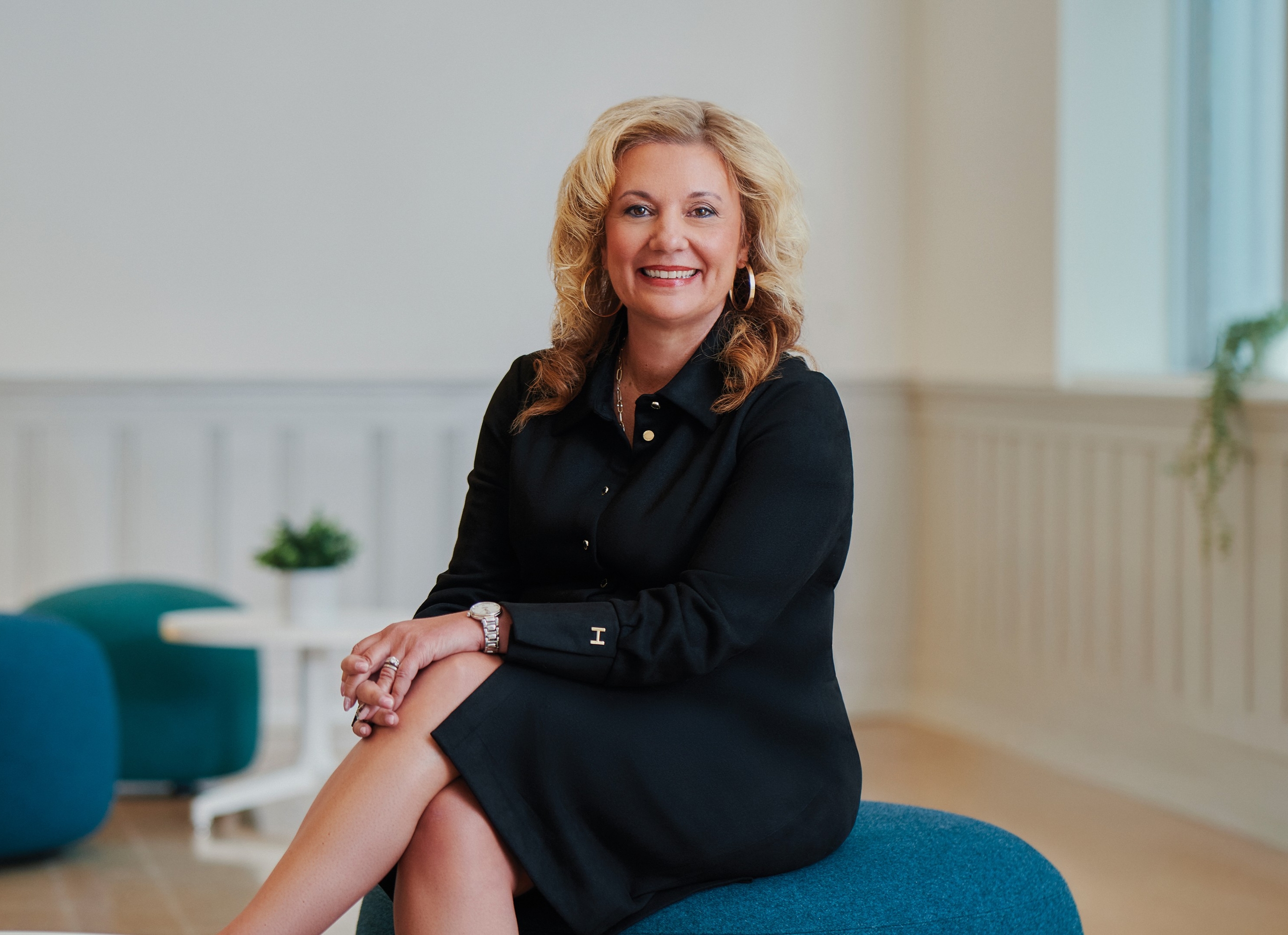 Roberta Iannacito-Provenzano poses sitting down wearing a collared black dress