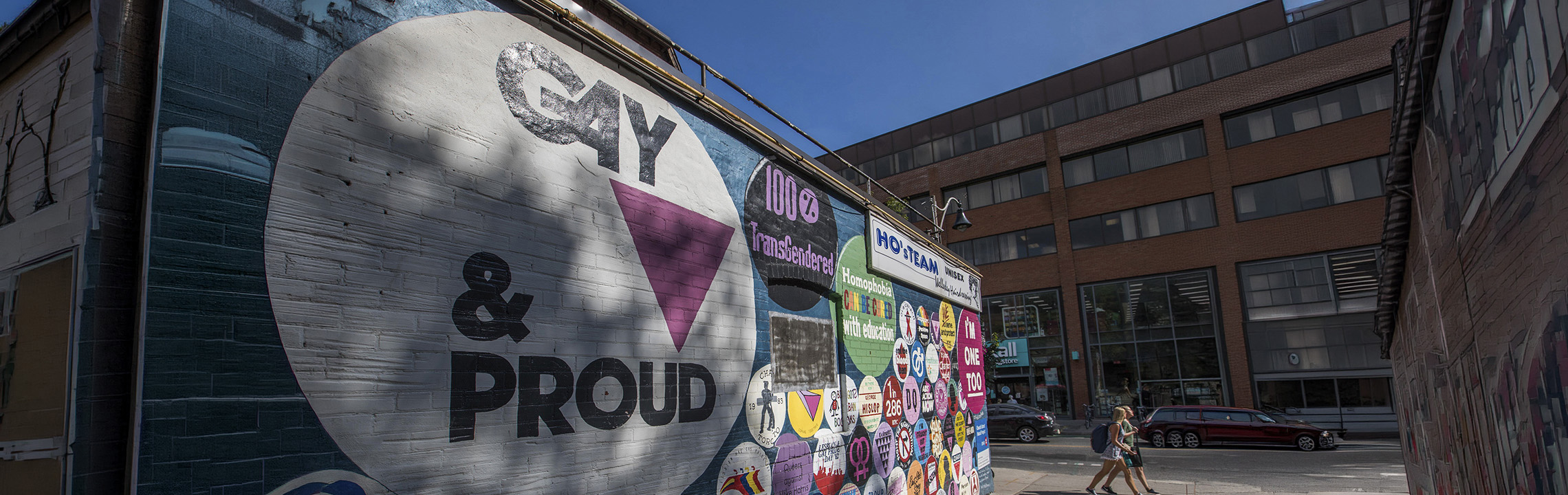 A mural painting on a wall with the words Gay and Proud