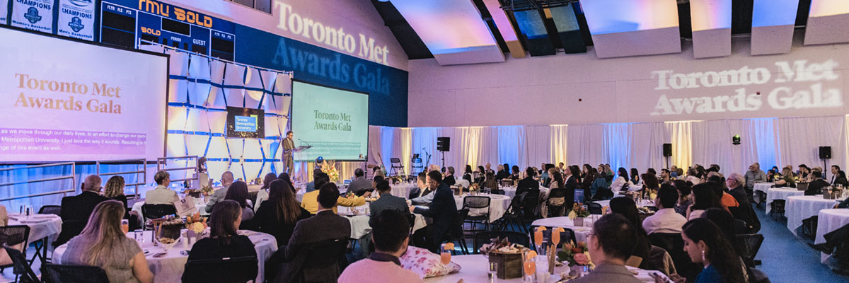 The audience at the Toronto Met Awards Gala seated at tables with soft blue and gold lighting.