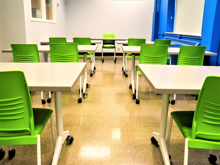 White tables and green chairs are laid out in KHW 277 room. 