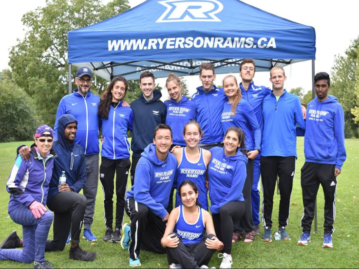 Members of the Ryerson Cross Country running club pose for a photo on a grassy lawn. 