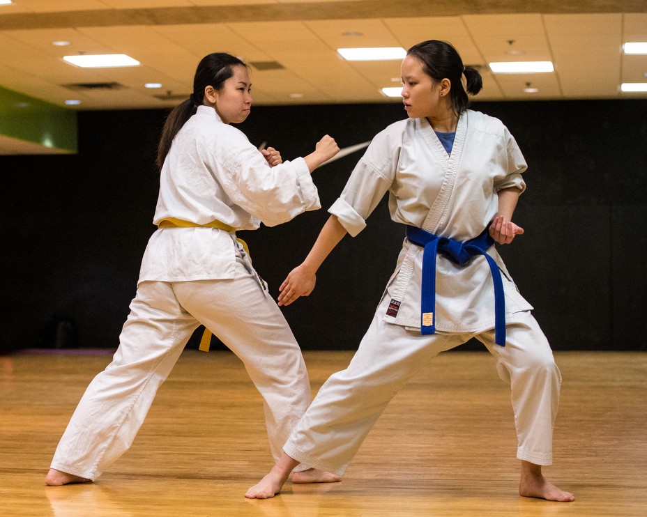 two martial arts students in white robes square up against each other in one of the studios