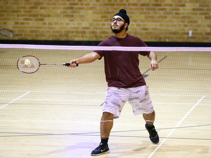 A young man prepares to hit approaching badminton birdy in one of the RAC gyms.