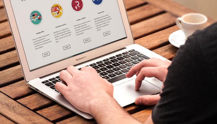 person's hands typing on a laptop