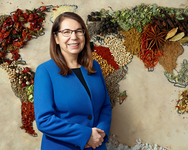 Nutrition Researcher, Cecilia Rocha, stands in front of a replica of the countries made from various foods.