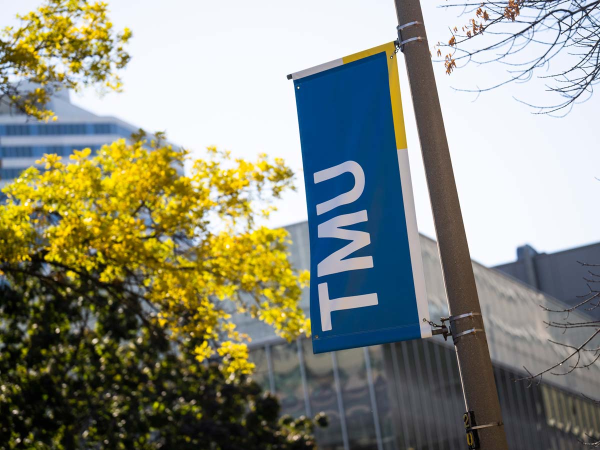 A TMU flag on the Toronto Metropolitan University campus.