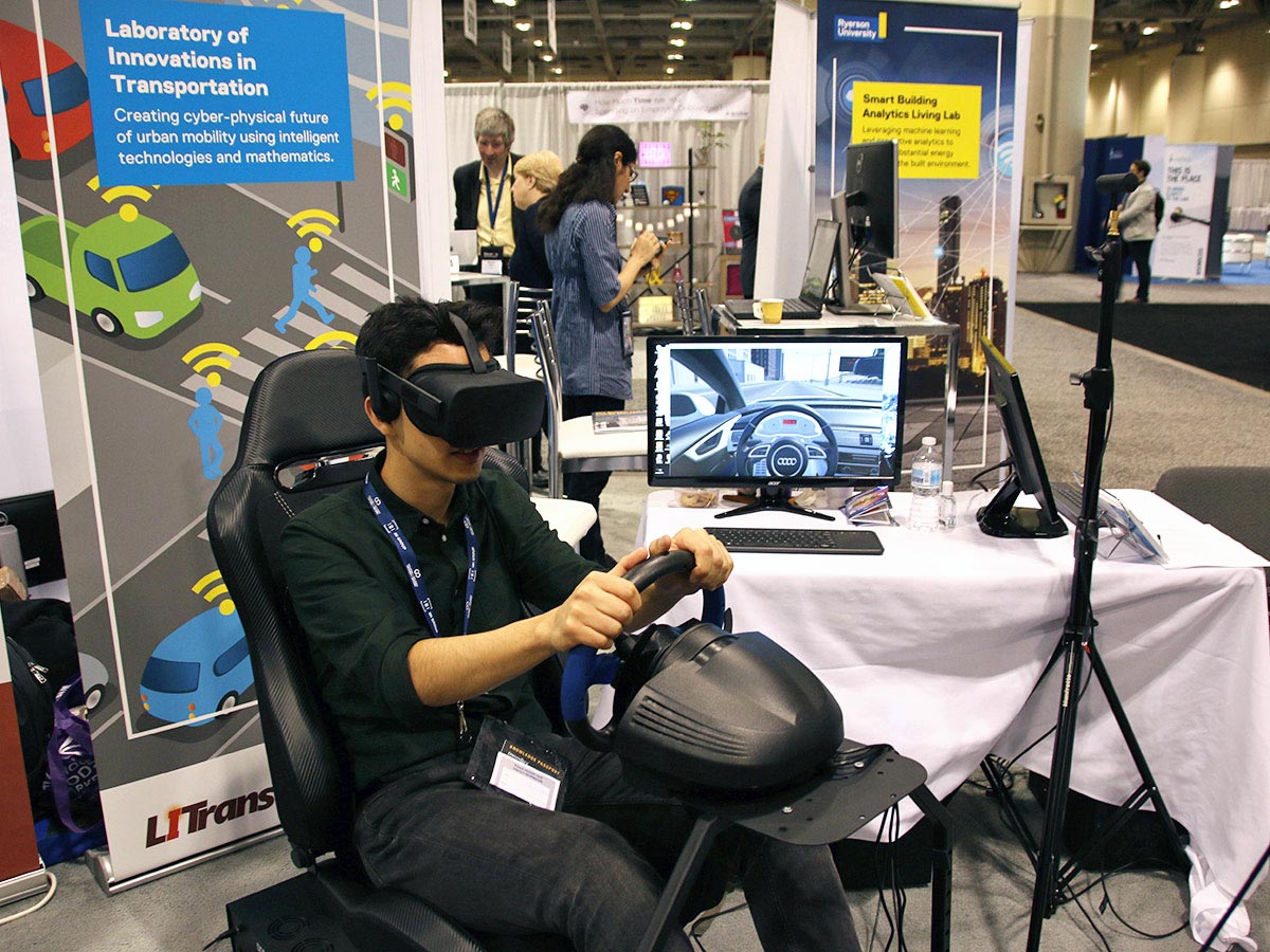 An attendee at OCE Discovery 2019 tries out a virtual reality driving simulator