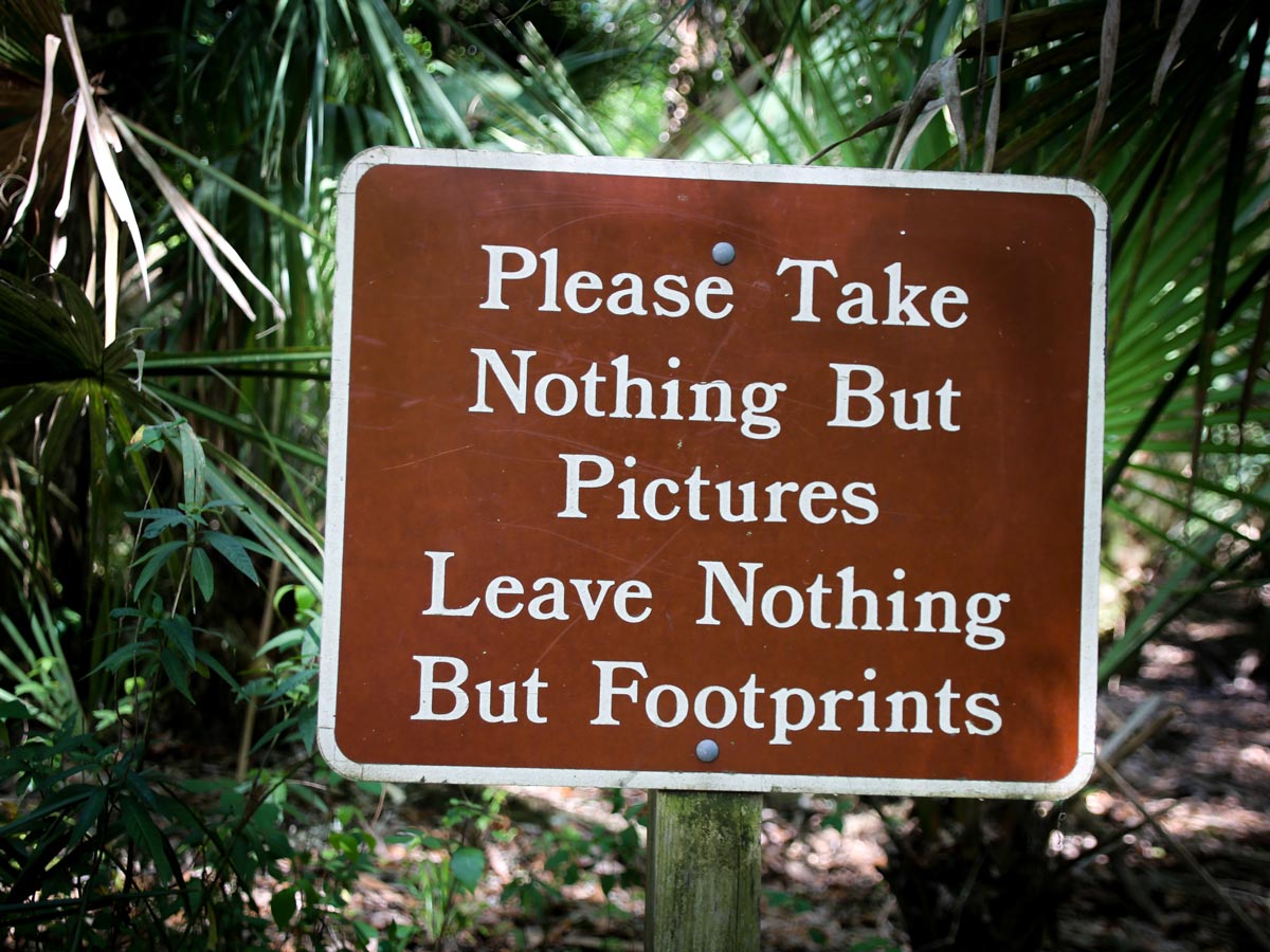 A sign that reads, "Please take nothing but pictures, leave nothing but footprints".