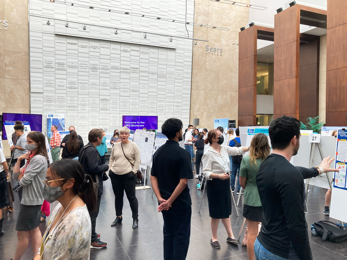 Attendees look at undergraduate student research posters in the Sears Atrium at the 2022 URO event. 