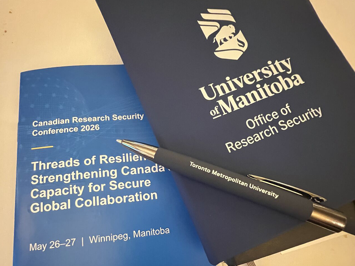 Canadian Research Security Conference 2026 program, University of Manitoba research security notebook and a Toronto Metropolitan University pen on a table