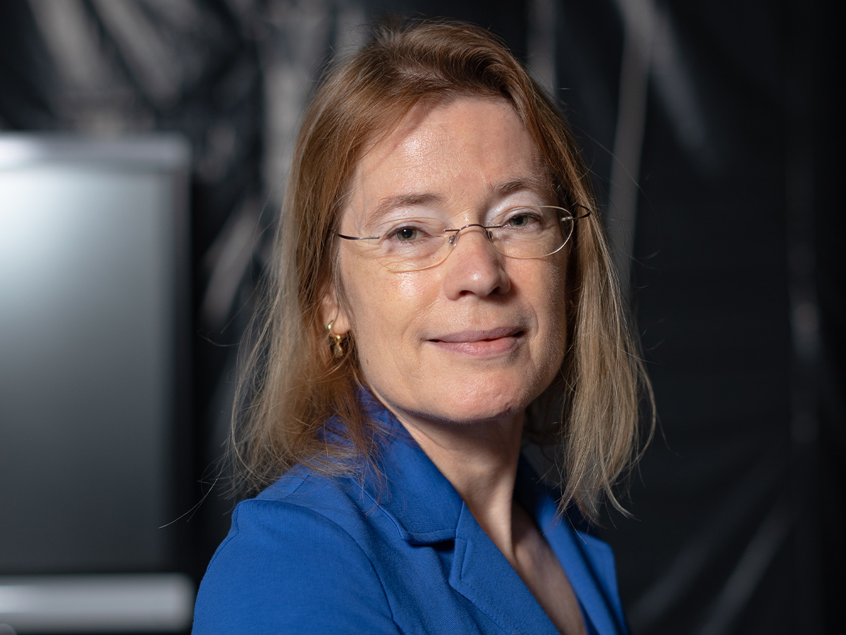 A portrait of professor Philomena Bluyssen wearing glasses and a blue shirt.