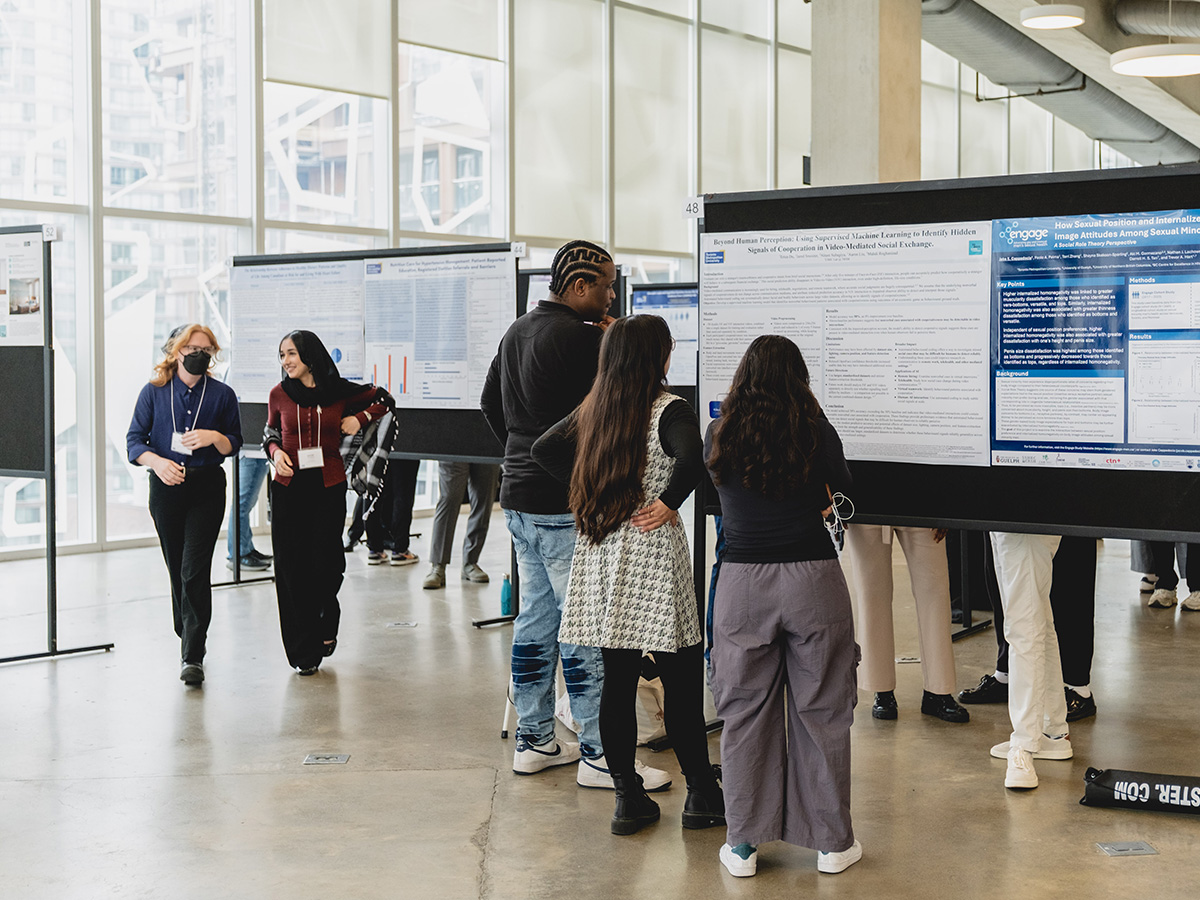 Students look at research posters in a sunny room
